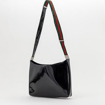 Gucci, a black, patent leather handbag.
