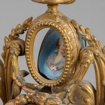 A Louis XVI style mantel clock and a pair of candelabra, circa 1900.