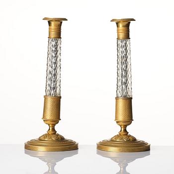 A pair of French gilt bronze and cut-glass Empire-style candlesticks, later part of the 19th century.