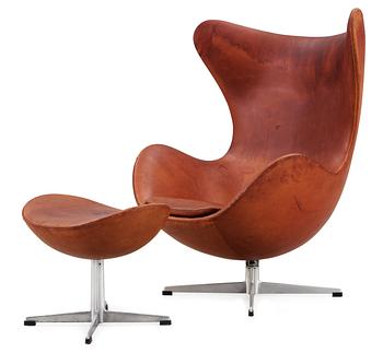 28. An Arne Jacobsen brown leather 'Egg chair' and ottoman,