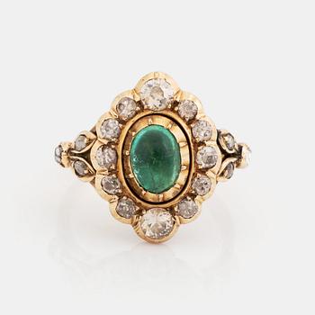 A 14K gold ring set with a cabochon-cut emerald and old-cut diamonds.