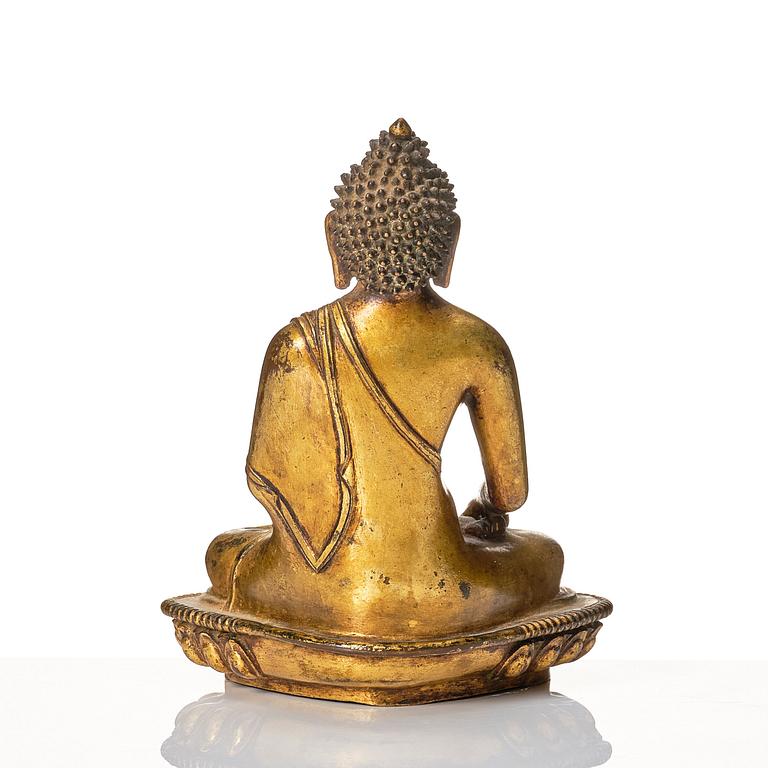 A gilt copper alloy figure of buddha, Nepal, 18th Century.