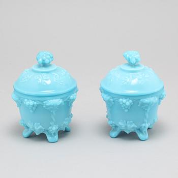 A pair of glass lided urns from the first half of the 20th century.