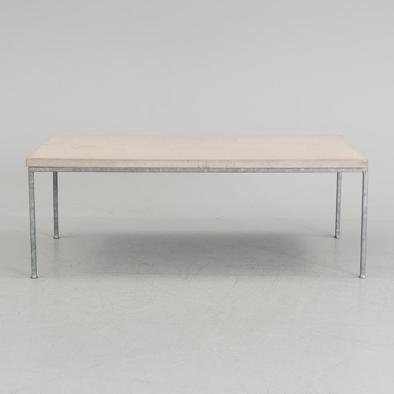 A modern sofa table with concrete top and steel legs.