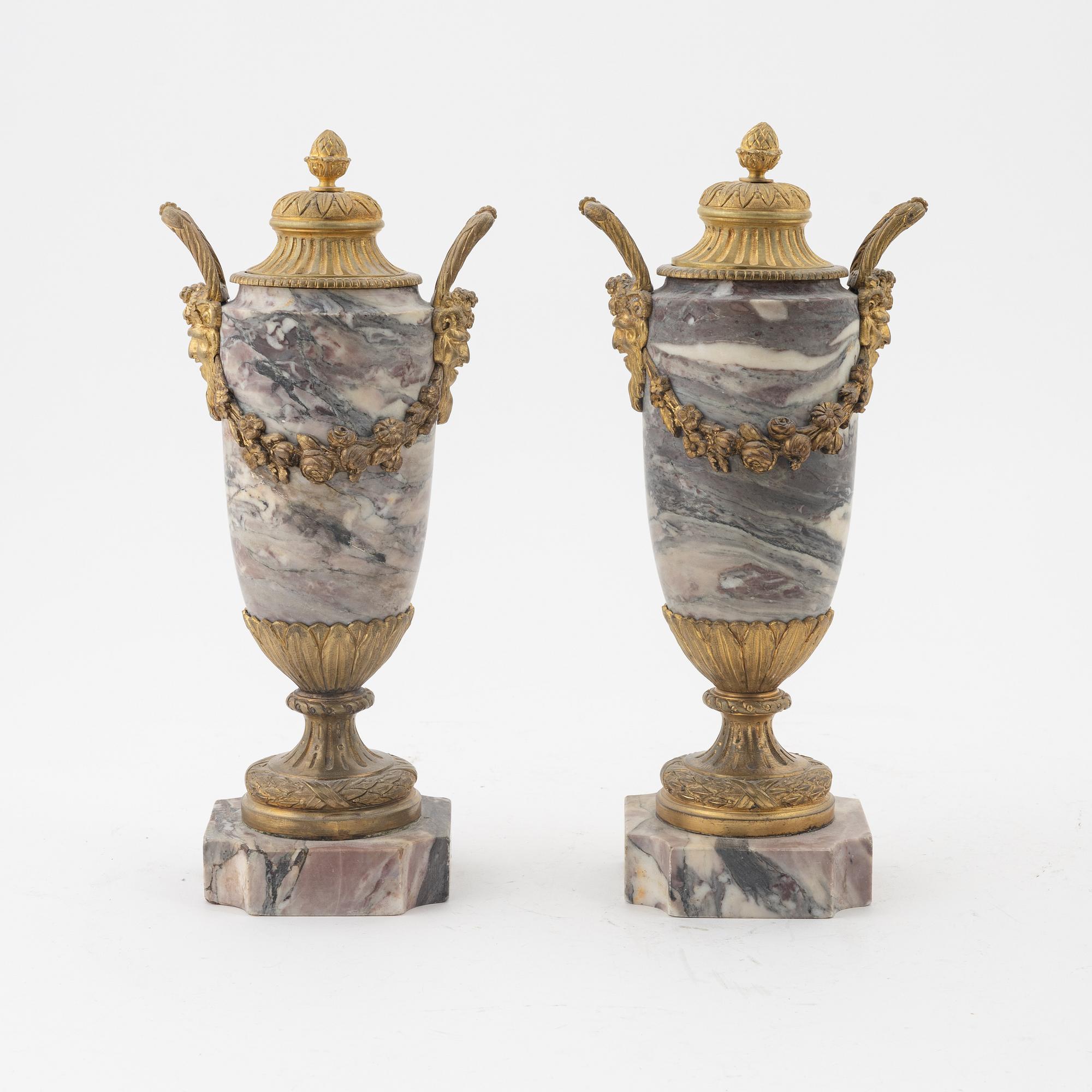 A pair of Louis XVI style urns with covers.