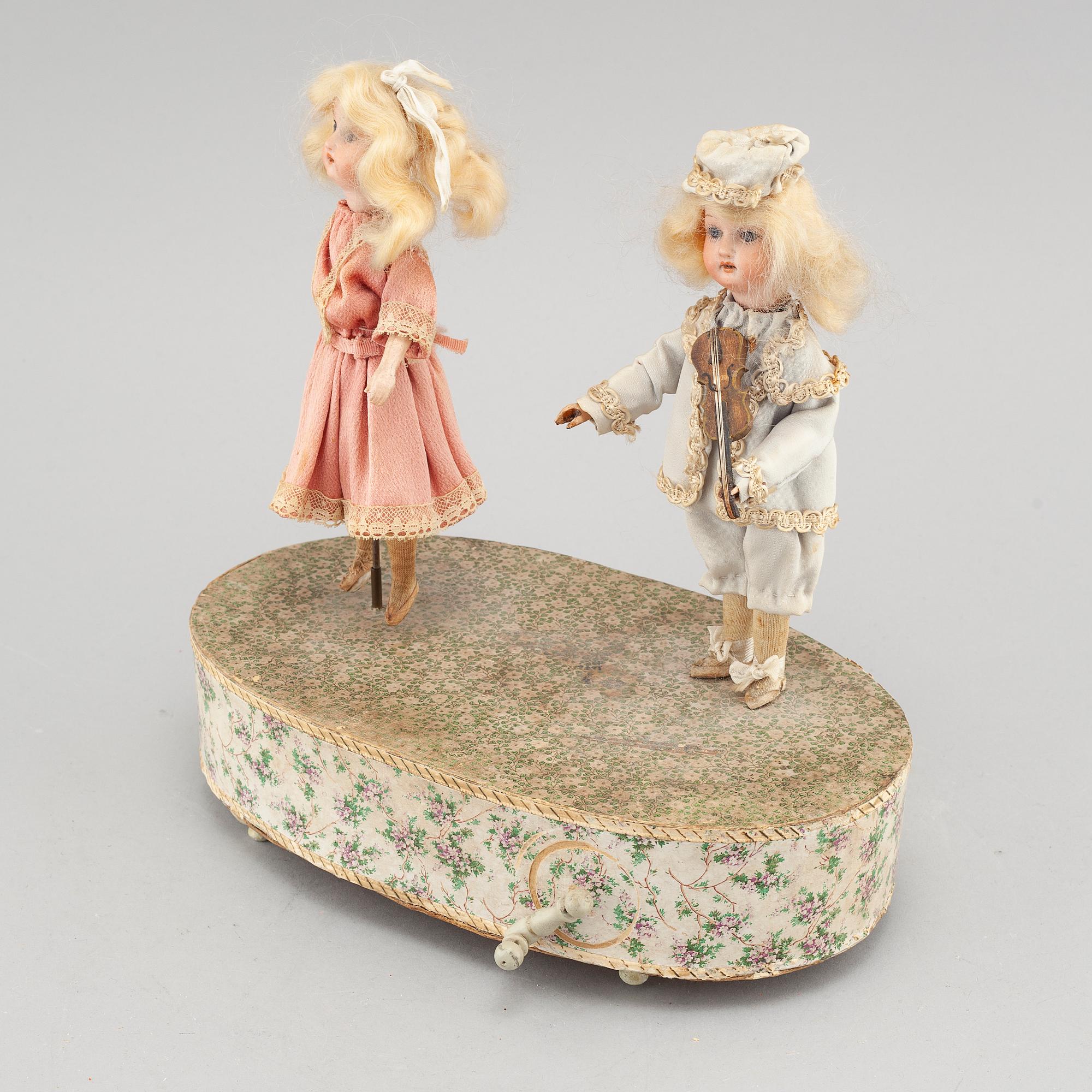 Dolls on a music box, around year 1900.