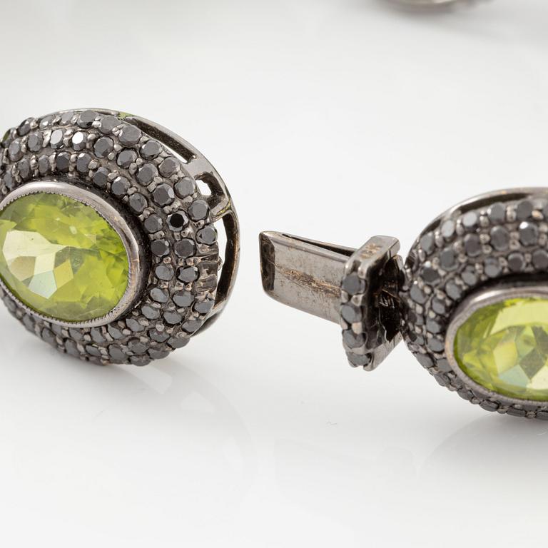 Bracelet in 18K gold with oval peridots and brilliant-cut black diamonds.