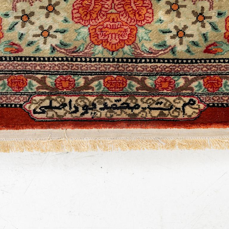 A signed silk Qum rug. c. 154 x 103 cm.