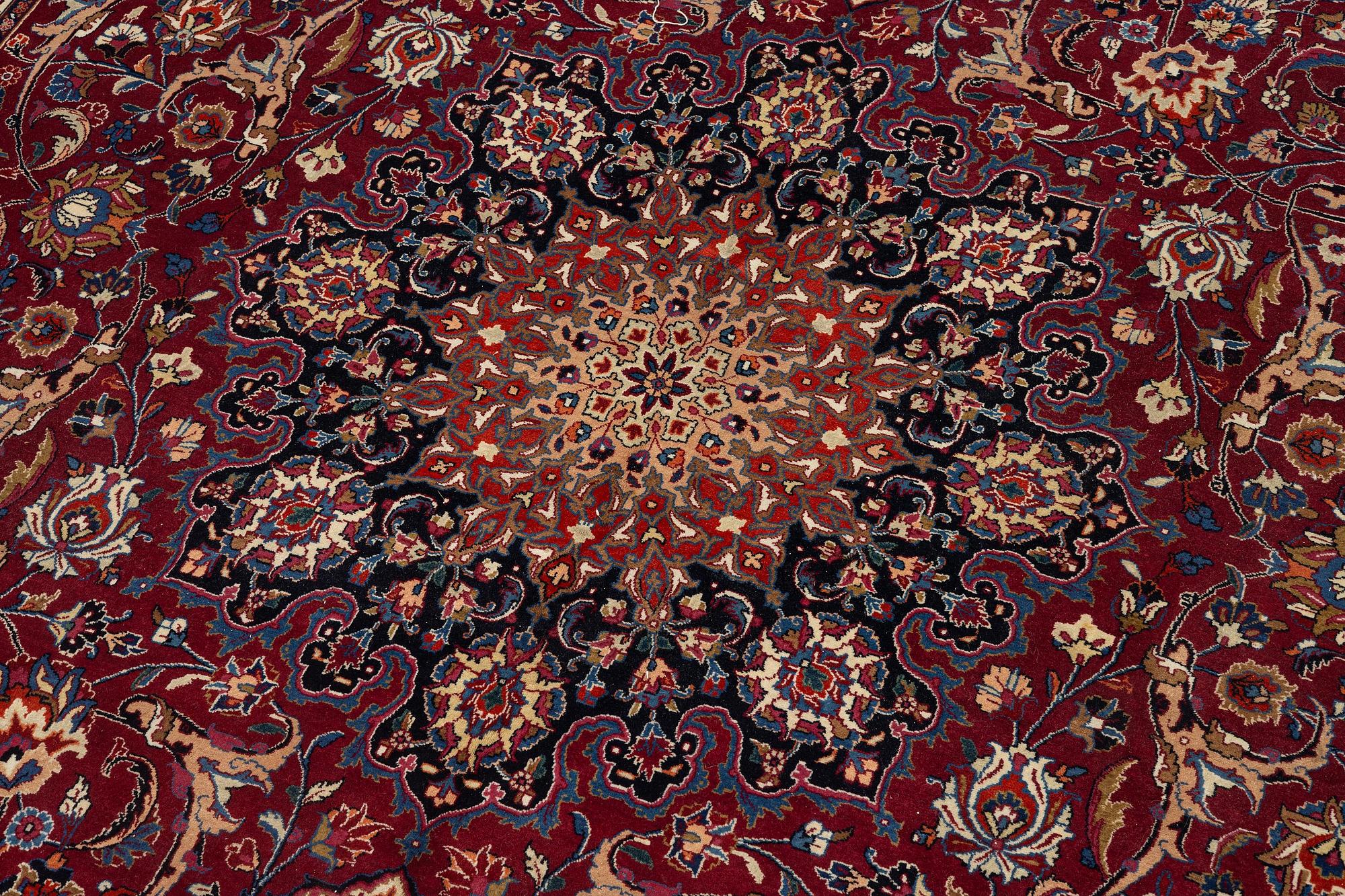 A semi-antique Mashad carpet, signed Saber, c. 401 x 300 cm.