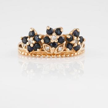 RING, 14K guld med sju briljantslipade diamanter samt femton blå safirer. Vikt 4,5 gram.