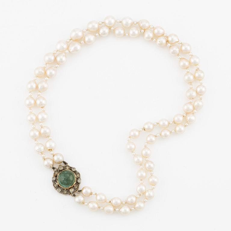 Necklace, double-stranded with cultured pearls, clasp by Engelbert Stigbert in 18K gold with cabochon-cut emerald and white stones.