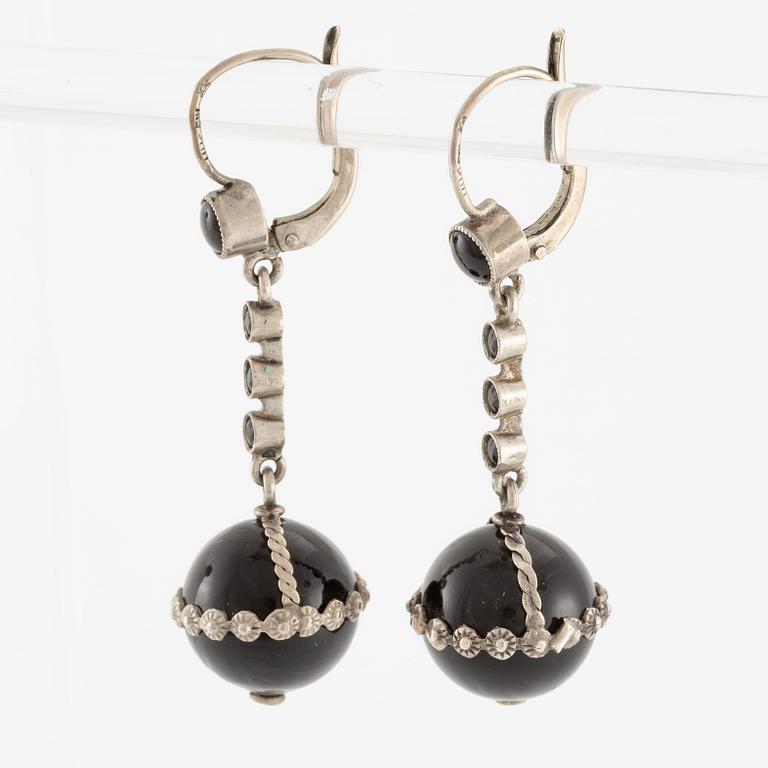 Örhängen silver med svarta stenar.