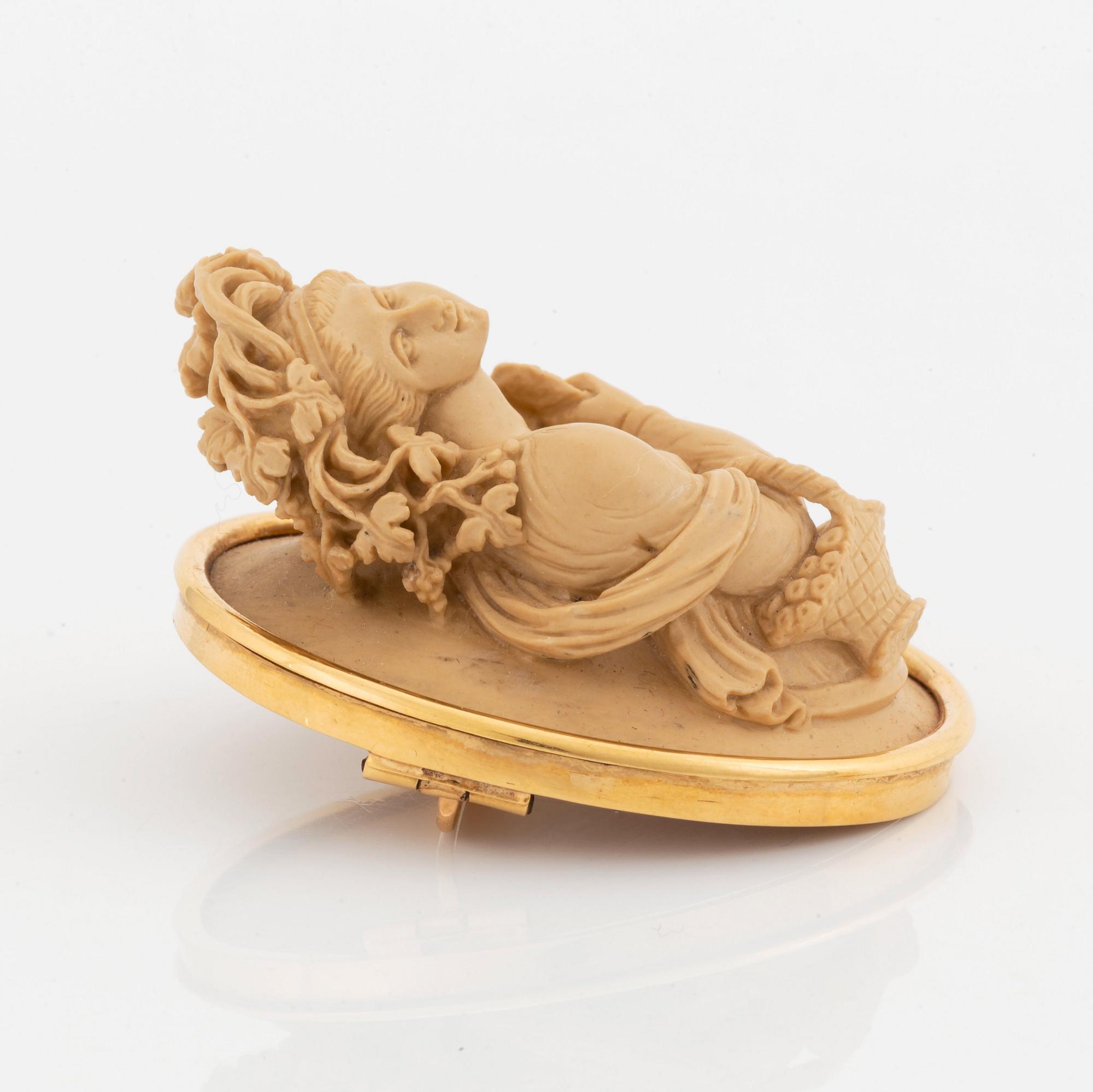An 18K gold and lava cameo brooch.