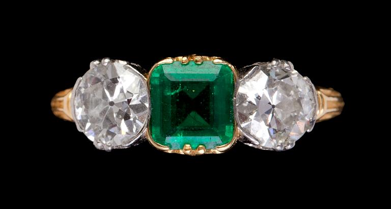 RING, smaragd med två gammalslipade diamanter, vardera ca 0.50 ct. Tidigt 1900-tal.