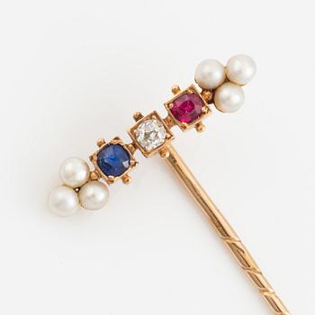 A 14K gold pin brooch with an old-cut diamond, pearls, and colored stones.