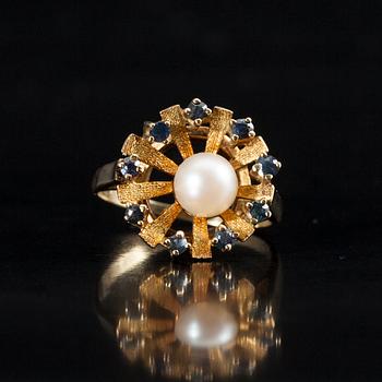 RING, 14K guld, 9 små safirer, en pärla i mitten. Finska importstämplar. Vikt 4,1 g.