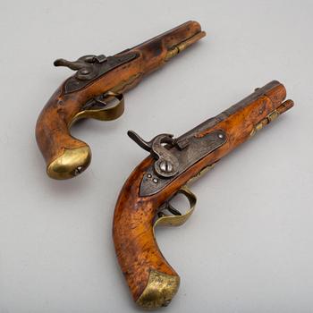 Two Swedish percussion pistols with birch stocks and brass mounts.