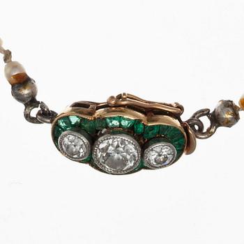 A NECLACE, oriental pearls 1,5 - 5 mm. Golden clasp with old cut diamonds c. 0.45 ct, emeralds. Early 1900 s.