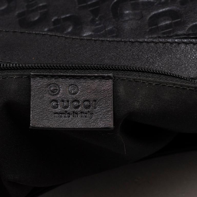 GUCCI, a black leather handbag.