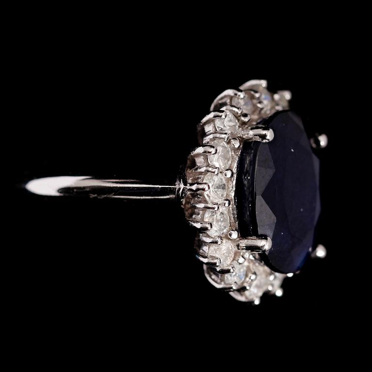 RING, 10 k vitguld, mörkblå safir ca 6.0 ct samt diamanter tot ca 1.0 ct.