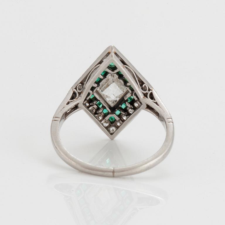 A RING set with diamonds and emeralds.