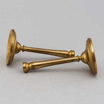 A pair of empire burnt gilt curtain holders, first half of the 20th century.