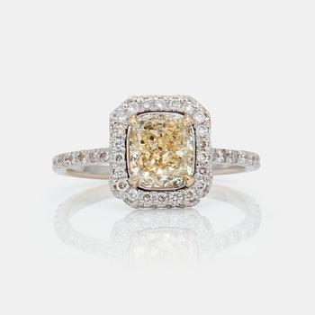 668. A cushion-cut fancy yellow/SI2 diamond ring. Pavé-set colourless brilliant-cut diamonds.