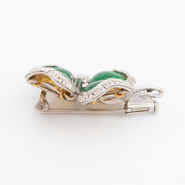 An 18K gold and enamel brooch set with round brilliant-cut diamonds.