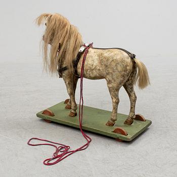 A painted early 20th century toy horse on wheels.