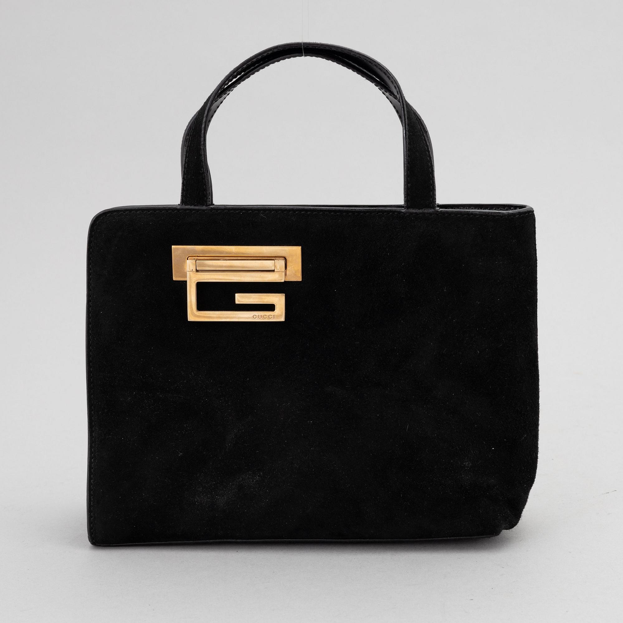 Gucci, a black suede handbag.