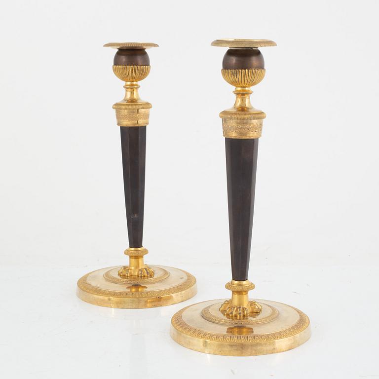 A pair of French gilt and patinated bronze Empire candlesticks, early 19th century.