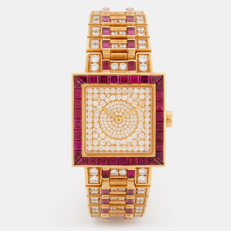 A Bulgari wristwatch in 18K gold set with step-cut rubies and round brilliant-cut diamonds.