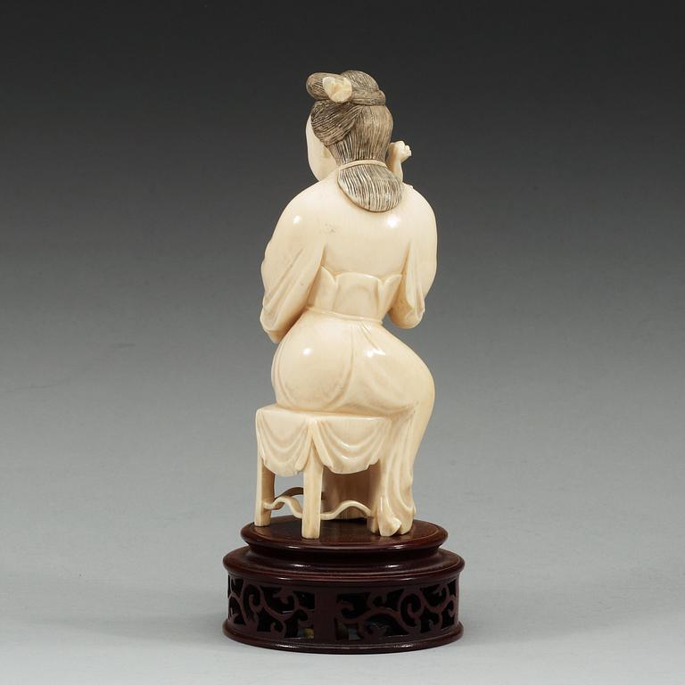 A ivory sculpture of a female musician, late Qing dynasty (1644-1912).