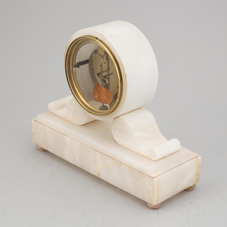 An alabaster mantle clock and pair of candlesticks, circa 1900.