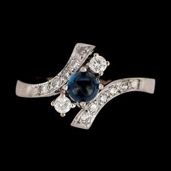 RING, cabochonslipad blå safir med diamanter, tot. ca 0.35 ct.