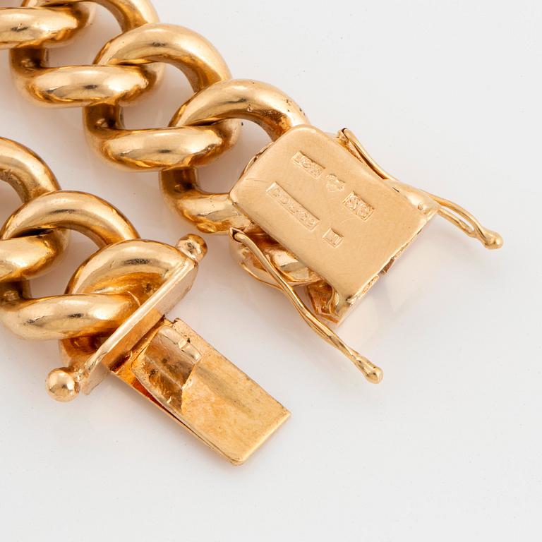 An 18K gold curb link bracelet.