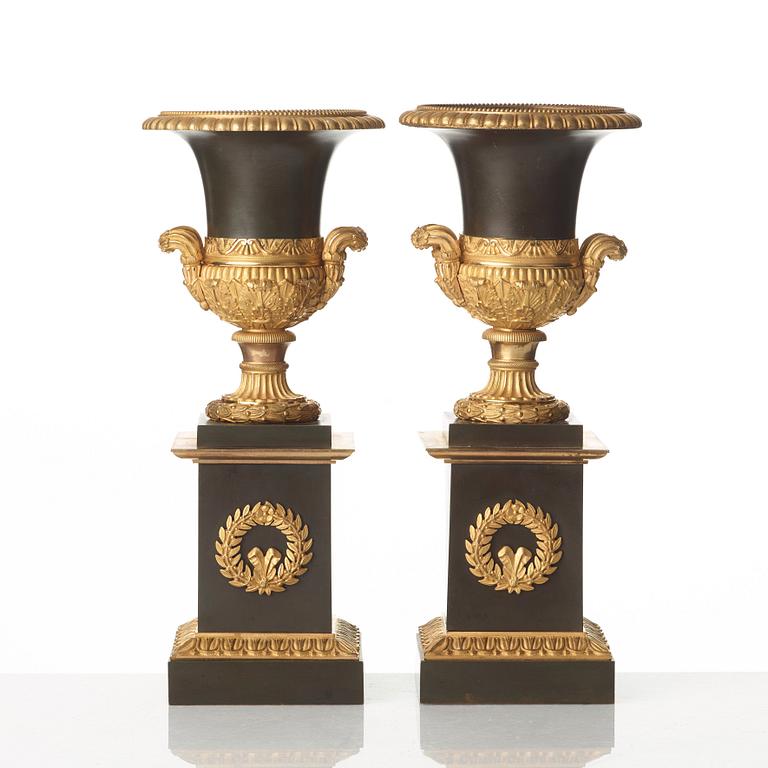 A pair of French Empire early 19th century gilt and patinated bronze urns.