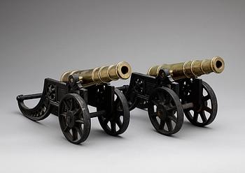 PRYDNADSKANONER, ett par, metall, 1900-talets första hälft.