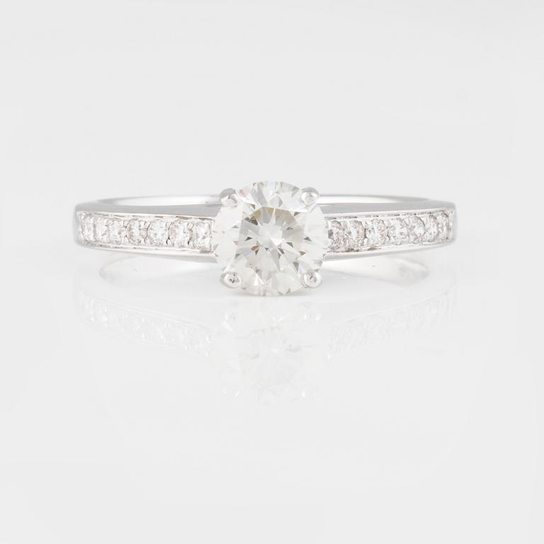 RING, 18K vitguld med briljantslipad diamant ca 0.70 ct samt små briljantslipade diamanter ca 0.15 ct. Vikt 2,9 gram.