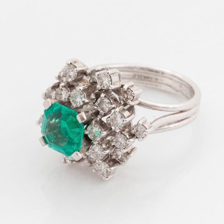 Ring platina med en fasettslipad smaragd och runda briljantslipade diamanter.