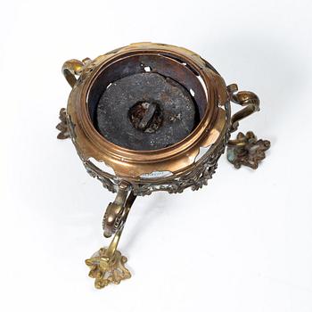 A German Rococo repoussé copper teapot on rechaud, mid 18th century.