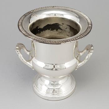 A 20TH CENTURY SILVERVED METAL CHAMPAGNE COOLER.