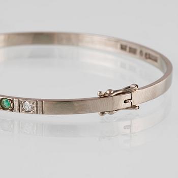 ARMRING, 18k vitguld med 5 briljantslipade diamanter och 4 smaragder, Sten Gramen, Göteborg, 1965. Vikt 13,3 gram.