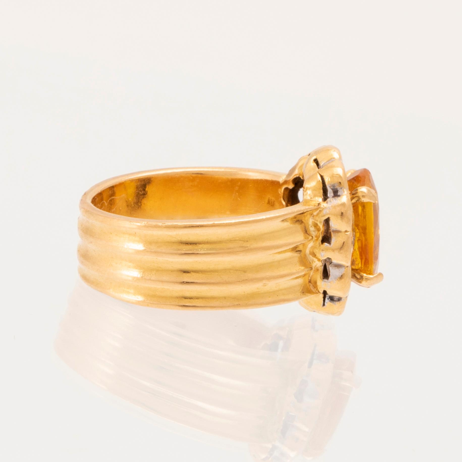 A 22K gold carmosé ring with an oval faceted yellow sapphire and round brilliant-cut diamonds.