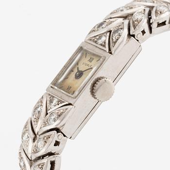 A Sterlé platinum wristwatch set with round brilliant-cut diamonds.