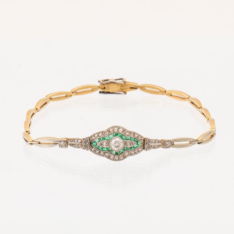 An 18K white and red gold bracelet set with emeralds between rose cut and old cut diamonds.