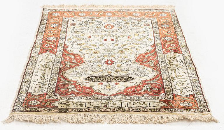 A silk and metal Hereke rug, c. 80 x 51 cm.