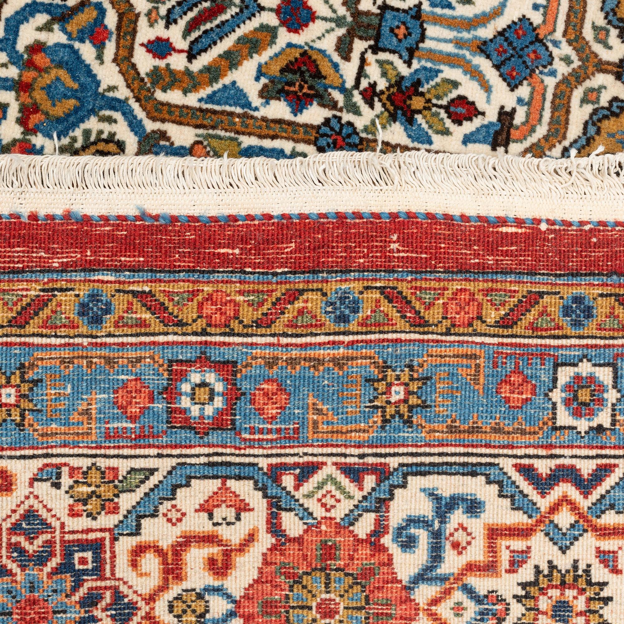 A carpet, semi-antique, Qum, ca 324 x 221 cm.