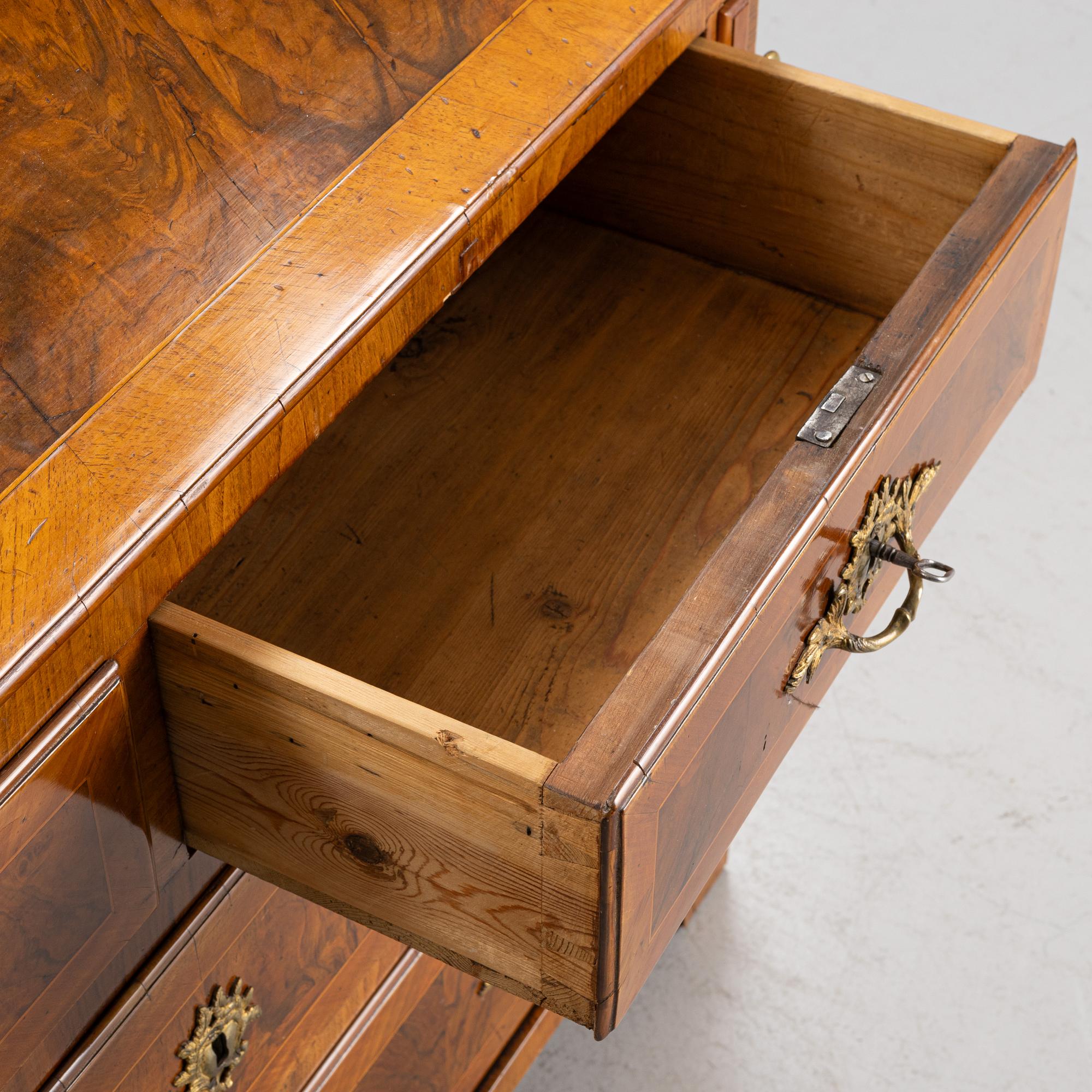 A rococo walnut-veneered and gilt-brass mounted secretaire, later part of the 18th century.