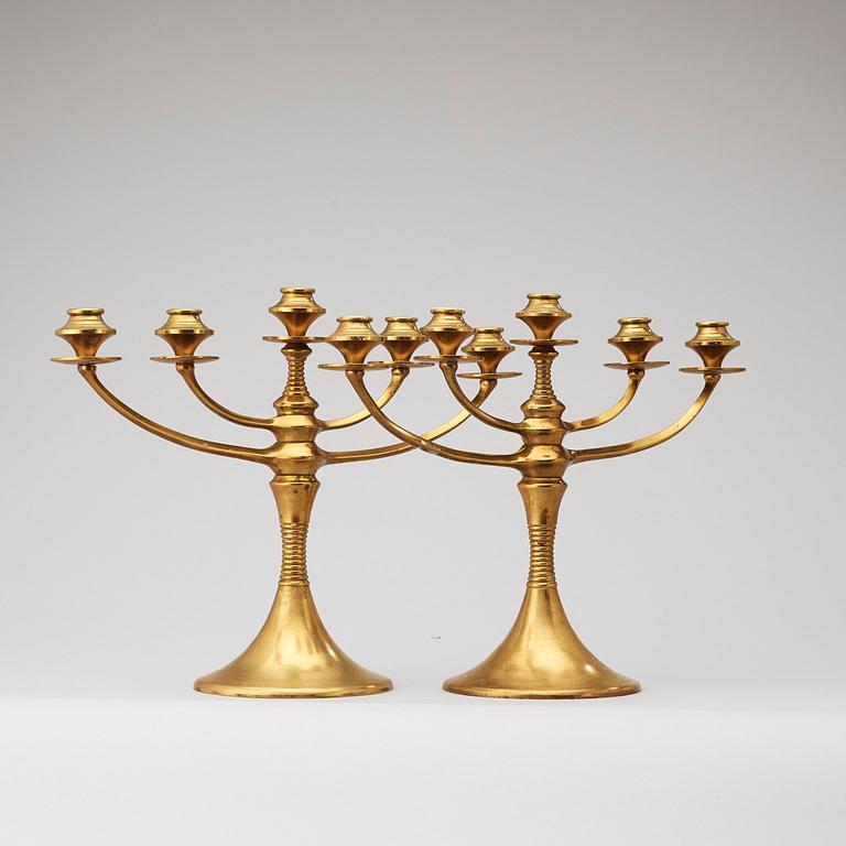 A pair of brass candelabra attributed to Bruno Paul, Germany, early 20th Century.